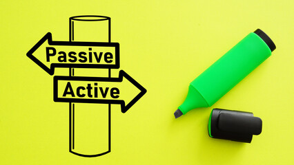 Passive - Active income signpost drawn on a yellow background. Active investing vs passive investing pros and cons.