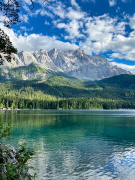Beautiful picture of Germany's highest mountain called Zugspitze overlooking a marvelous mountain lake with turquoise water reflecting the mountain range on a summer day. Vacation feelings. 