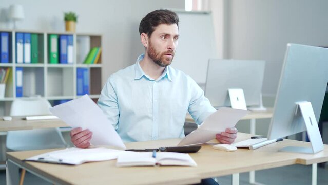 Difficult for a male employee to deal with paperwork. documents. Stressed caucasian businessman confused by mistake, looking through papers. bookkeeper, booker vaguely, dimly sitting at work in office