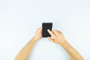 Man hands surfing on the net with a mobile phone, black screen, cellphone with copy space, clicking or touching on screen, top view
