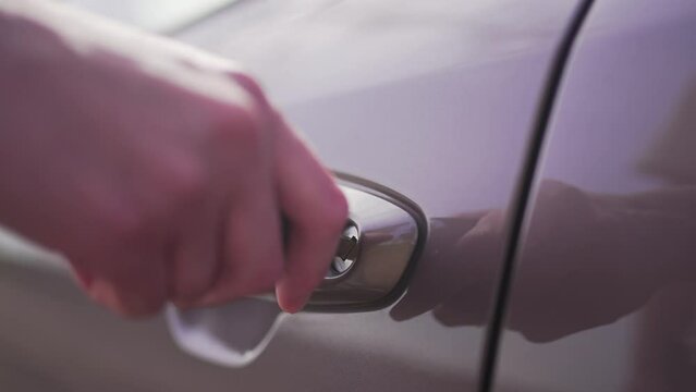 Person opens or closes the car door with a key. Mechanical open transport. Close-up 4K 10 BIT