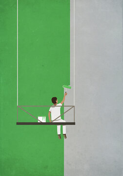 Man on hanging platform painting wall green
