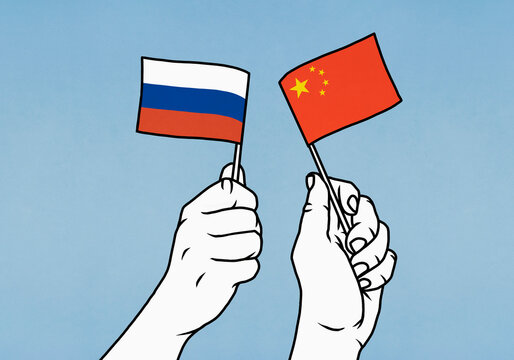 Hands waving flags of Russian and China
