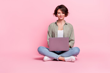 Full length portrait of pretty charming girl use wireless netbook chatting isolated on pink color...