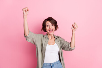 Photo of cheerful lady impressed unbelievable prize award fists up isolated over pastel color background