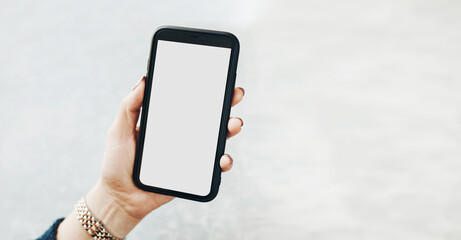 Female hand holding smartphone mockup with solid white color blank empty isolated screen on plain background. Person using technology. Mobile phone with copy space right