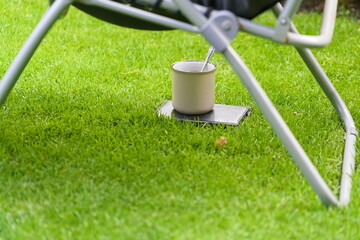 A cup with a drink on the lawn in the summer