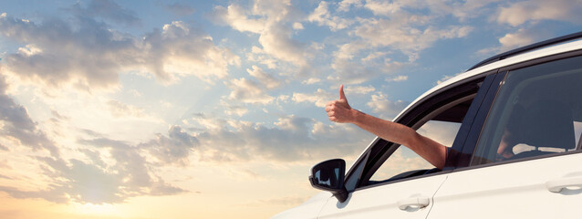 Happy man holding hand outside open window car with sky clouds background. People lifestyle...