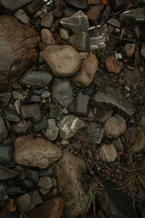 Large wet stones on the ground. Mountain road