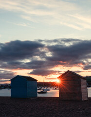 Beach Huts On Teignmouth's Back Beach At Sunset