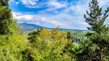 Fototapeta na wymiar View from Krkavčí Skály (Vajoletky) to Ještěd ridge. Rocks near Křižany near Ještěd in the Liberec region. Spring romantic landscape in the Czech Republic.