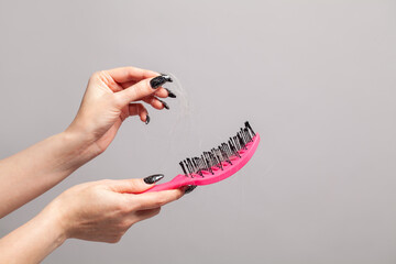 Hair loss concept. Hair and comb in female hands