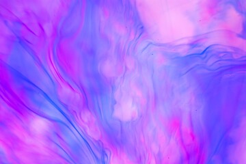 Shallow depth of field shot of swirling pink and blue ink in water - soft flowing abstract and soothing backdrop