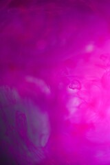 Shallow depth of field shot of swirling pink and blue ink in water - soft flowing abstract and soothing backdrop