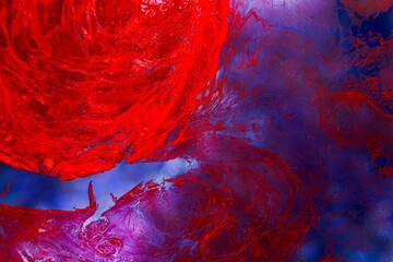 Shallow depth of field shot of a blob of dried red ink floating in water