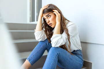 Upset young caucasian beautiful businesswoman tired from work sitting at stairs, unemployment, fired from job, disappointed, loss and feeling down concept