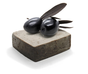 Natural handmade black olive oil soap and two black olives on white background