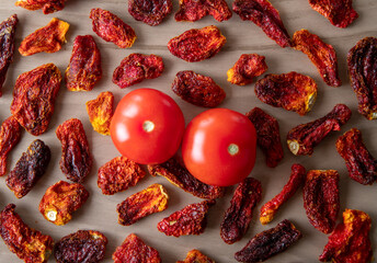 Fresh tomatoes and sun dried tomatoes with on wooden background	