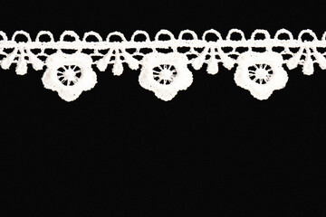 White lace on black background isolated. Sewing and fabric concept