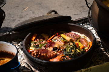Serbian pork knuckle (svinjska kolenica) stewed under sać pot with potatoes and vegetables