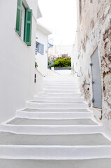Narrow medieval street with white stone steps in old mediterranean town