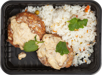 Rice with meatballs in a disposable rectangular plastic black lunch box top view on a white background