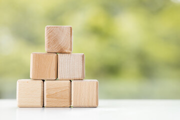 Group of wooden cube block on green summer background with copy space