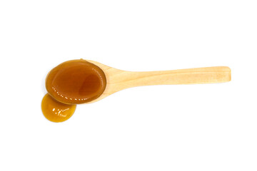 Date syrup and wood spoon on white background - top view