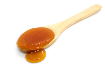  Date syrup and wood spoon on white background