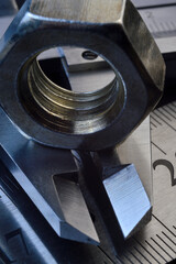 Accurate measuring tool caliper and metal ruler lie in place with nuts. close-up.