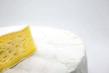 Piece of camembert isolated on white background