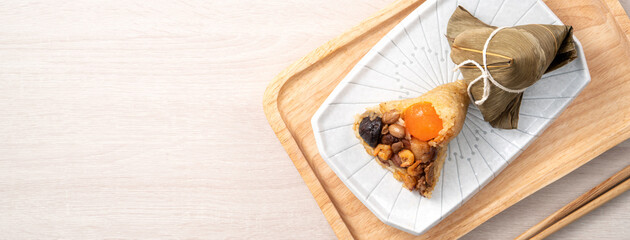 Zongzi. Rice dumpling for Dragon Boat Festival on bright wooden table background with ingredient.