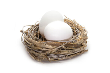 Set of two white egg in a straw nest on the white background