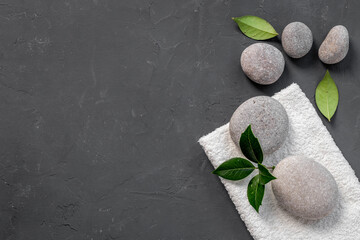 Obraz na płótnie Canvas Spa massage stones with green leaves. Beauty treatment background