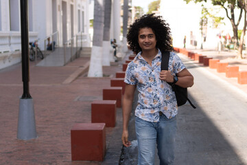 African American college student, with backpack, walking down the street.