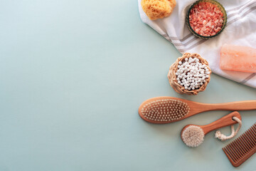 Natural cosmetics, wooden brushes, ear cleaning sticks, comb, sponge, soap and pink himalayan salt on light blue table. Beauty, spa and wellness. Zero waste concept. Top view, flat lay, copy space - obrazy, fototapety, plakaty