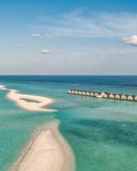 Fototapeta premium Maldives paradise scenery. Tropical aerial landscape, seascape with long jetty, water villas with amazing sea and lagoon beach, tropical nature. Exotic tourism destination banner, summer vacation 