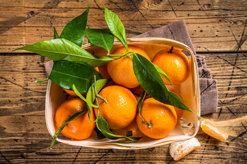 Fresh organic Tangerines, mandarins in wooden box from supermarket. Wooden background. Top view