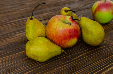 Pears and apples on wooden background
