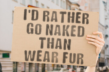 The phrase " I’d rather go naked than wear fur " is on a banner in men's hands with blurred background. March. Loud. Legislation. Policy. Problem. Sad. Crowd. Activist. Jacket. Mink. Farm. Cruel