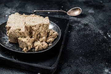 Homemade sunflower halva with honey. Black background. Top view. Copy space