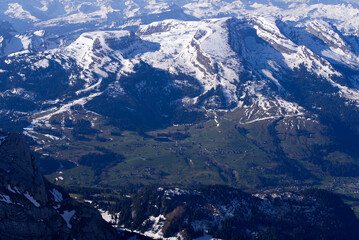 Fototapeta premium Aerial view over the Swiss Alps with Churfirsten and Toggenburg Valley seen from Säntis peak at Alpstein Mountains on a sunny spring day. Photo taken April 19th, 2022, Säntis, Switzerland.