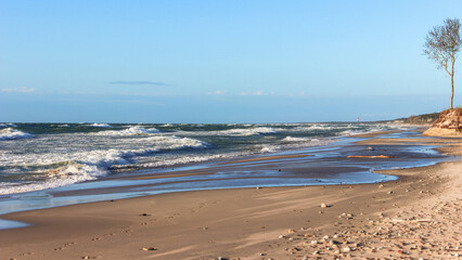 wide beach waves on the sea on a clear sunny day