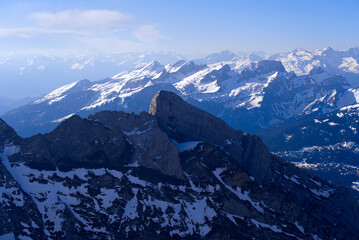 Aerial view over the Swiss Alps with rock seen from Säntis peak at Alpstein Mountains on a sunny spring day. Photo taken April 19th, 2022, Säntis, Switzerland.