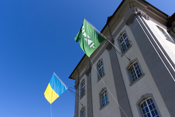 Flags of Canton St. Gallen and the Ukraine at government building blowing in the wind on a sunny spring day. Photo taken April 19th, 2022, St. Gallen, Switzerland.