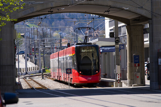 Red train of Appenzeller Railways arriving at railway station at City of St. Gallen on a sunny spring day. Photo taken April 19th, 2022, St. Gallen, Switzerland.