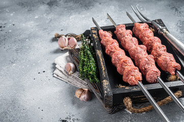 Shish kebab from Raw mince lamb and beef meat, turkish adana kebab. Gray background. Top view. Copy space