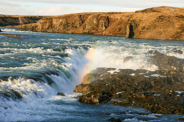 Rainbow captured ofer a small waterfall in an icelandic river