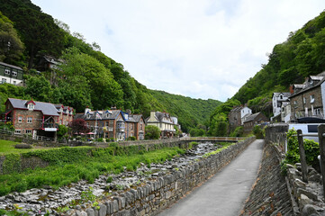 Fototapeta na wymiar 20 May 2022: Lynmouth, Devon, England, UK - A view of the River Lyn and Mars Hill on a sunny day. Coastal village of Lynmouth in Devon on the northern edge of Exmoor National Park.