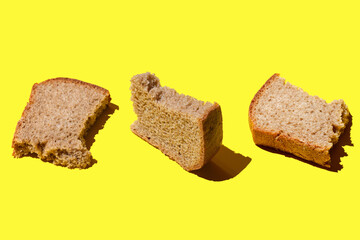 Three pieces of black bread on a yellow background, three crusts of bread, assorted bread, black bread with sliced slices
